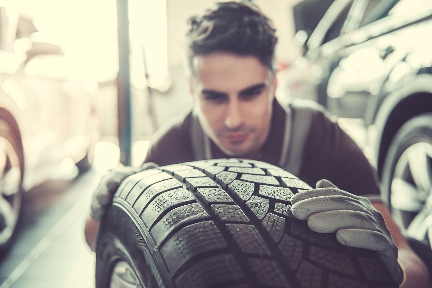 Kia Service Technician Checking a Tire's Tread
